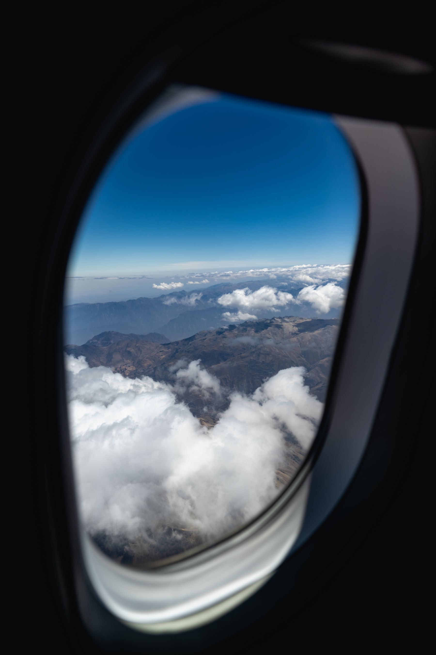 Mountain peaks and clouds through an airplane window